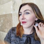 Jeune femme portant les boucles d'oreille de couleur blanches et bleu turquoise en cuivre émaillé